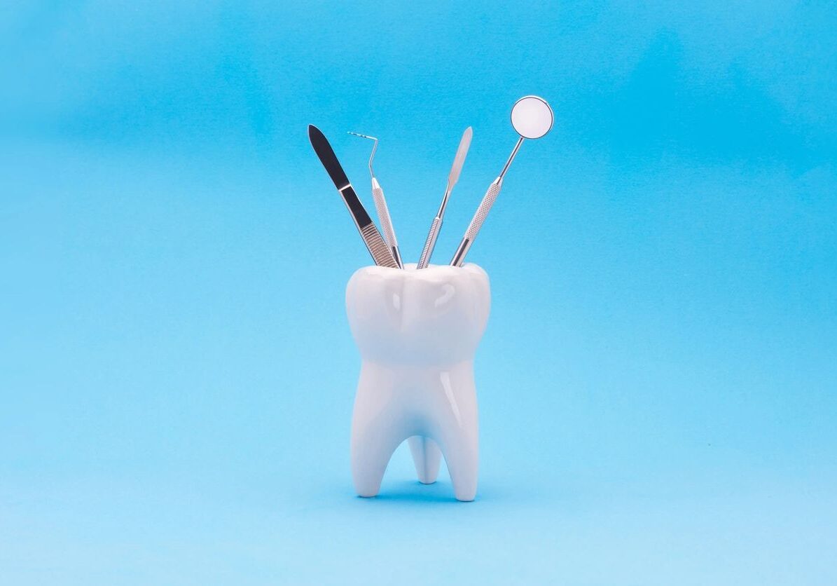 tooth holding dental tools blue bakcground